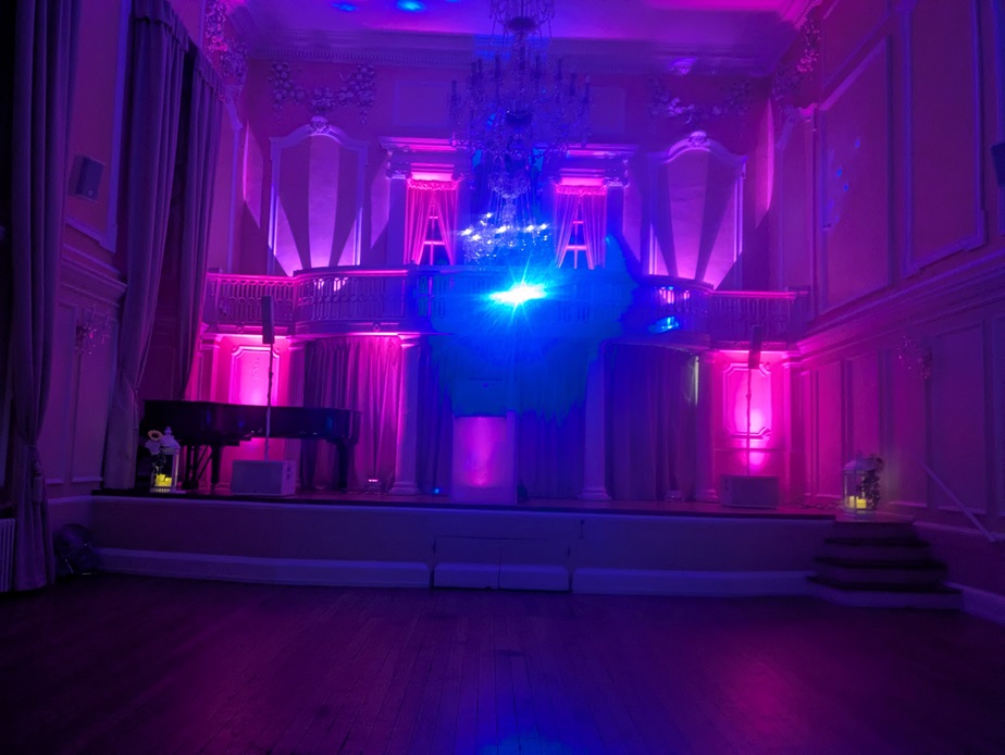 Darker, moody disco setup with red and purple lighting for a high-energy wedding party